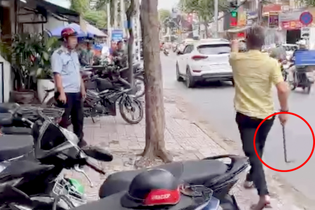 Ông Hoàn cầm xà beng dọa đánh cán bộ phường. Ảnh cắt từ clip.