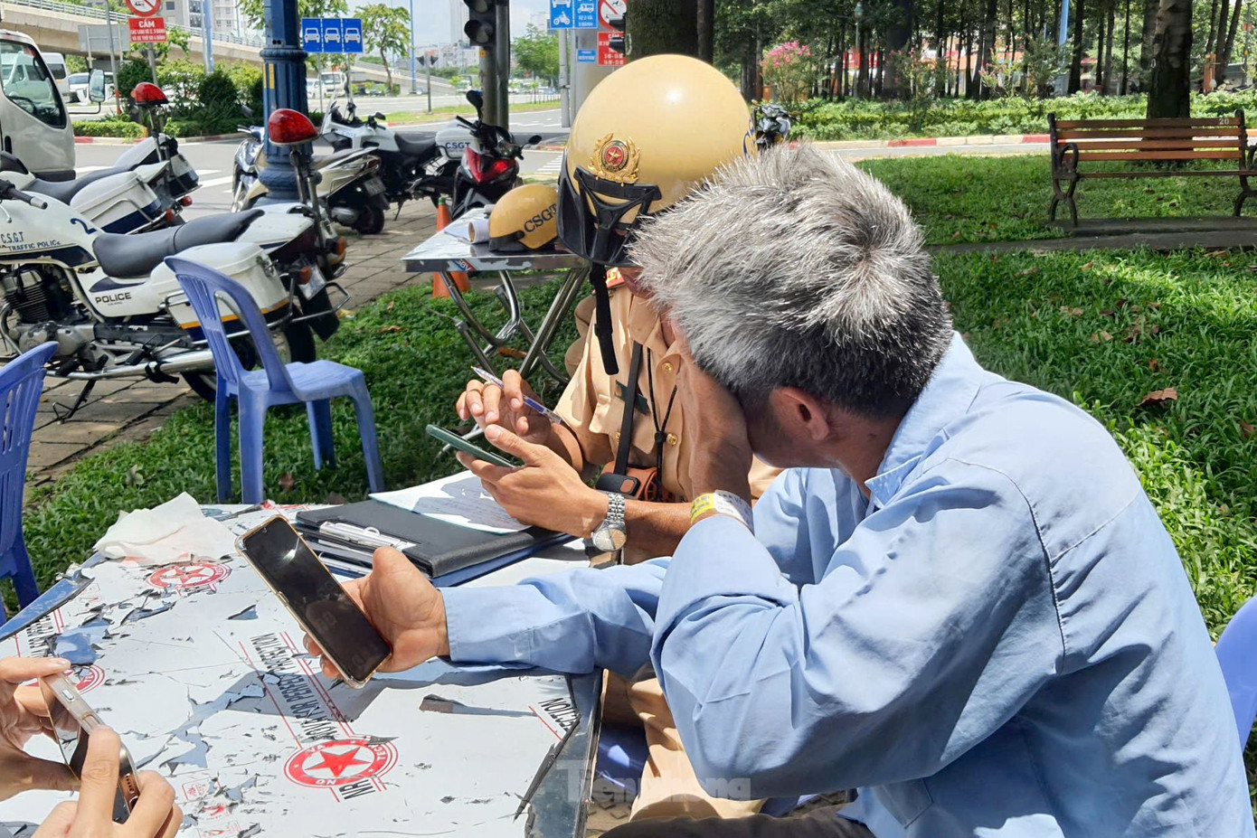 Ông H. khóc rơm rớm nước mắt khi được CSGT hỗ trợ đóng tiền phạt. Ảnh: Hoàng Thuận