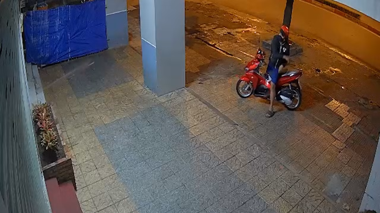 Lộc đi xe máy đến nhà ông Dũng để ném sơn vào cửa (Ảnh cắt từ clip). Lộc đi xe máy đến nhà ông Dũng để ném sơn vào cửa (Ảnh cắt từ clip).