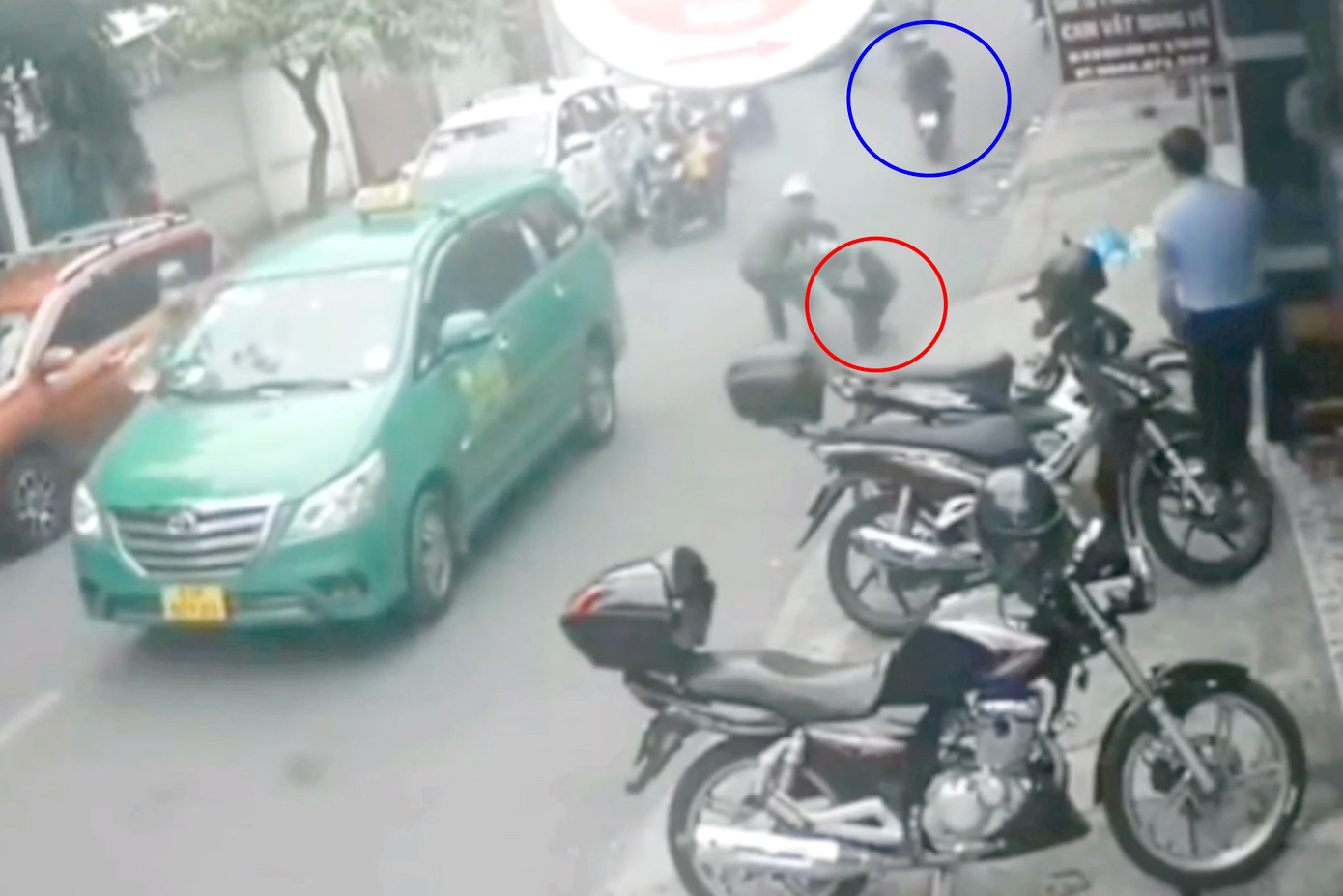 Thấy chiến sĩ công an quật ngã đối tượng chạy bộ (khoanh tròn đỏ), hai đối tượng ngồi trên xe máy (khoanh tròn xanh) tăng ga tẩu thoát (Ảnh cắt từ clip).