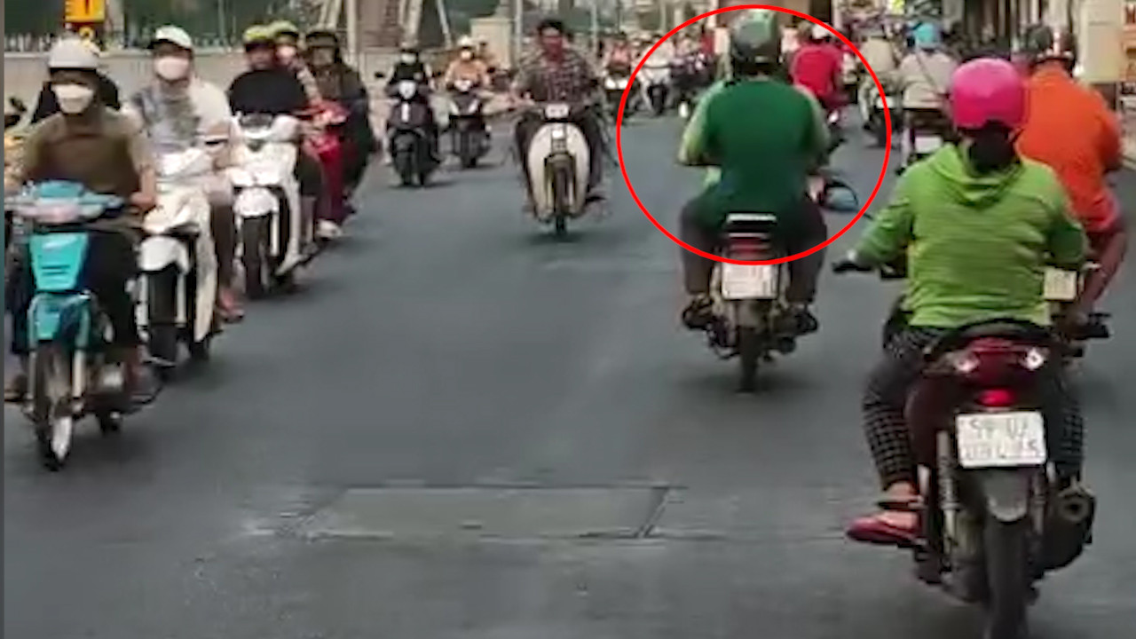 Sau khi giết người, phóng hỏa, nghi phạm (khoanh tròn đỏ) đón xe ôm tẩu thoát. Ảnh cắt từ clip.