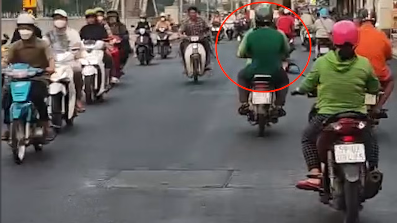 Sau khi giết người, phóng hỏa, nghi phạm (khoanh tròn đỏ) đón xe ôm tẩu thoát. Ảnh cắt từ clip. Sau khi giết người, phóng hỏa, nghi phạm (khoanh tròn đỏ) đón xe ôm tẩu thoát. Ảnh cắt từ clip.