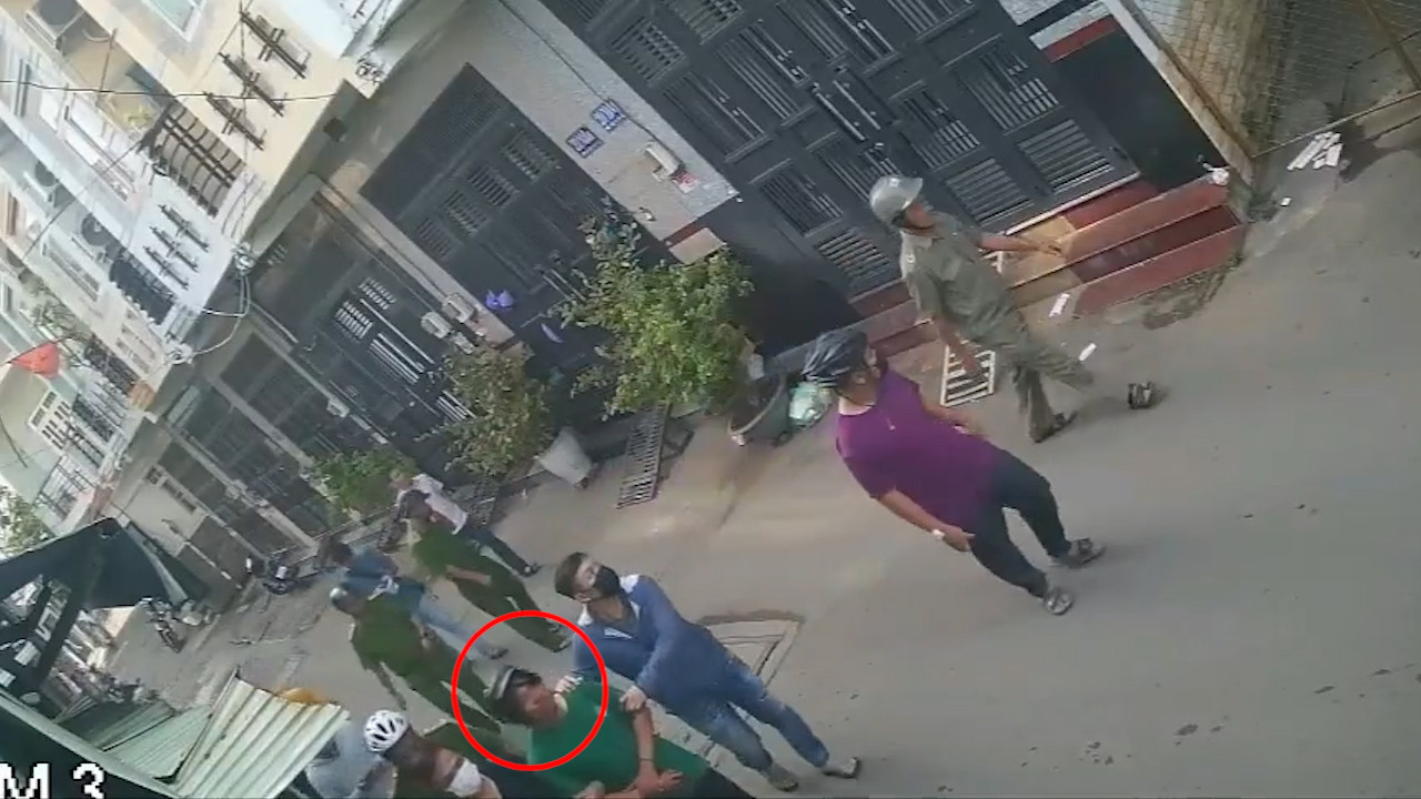 Lực lượng chức năng đưa Nhu (khoanh tròn đỏ) quay trở lại hiện trường. Ảnh cắt từ clip.