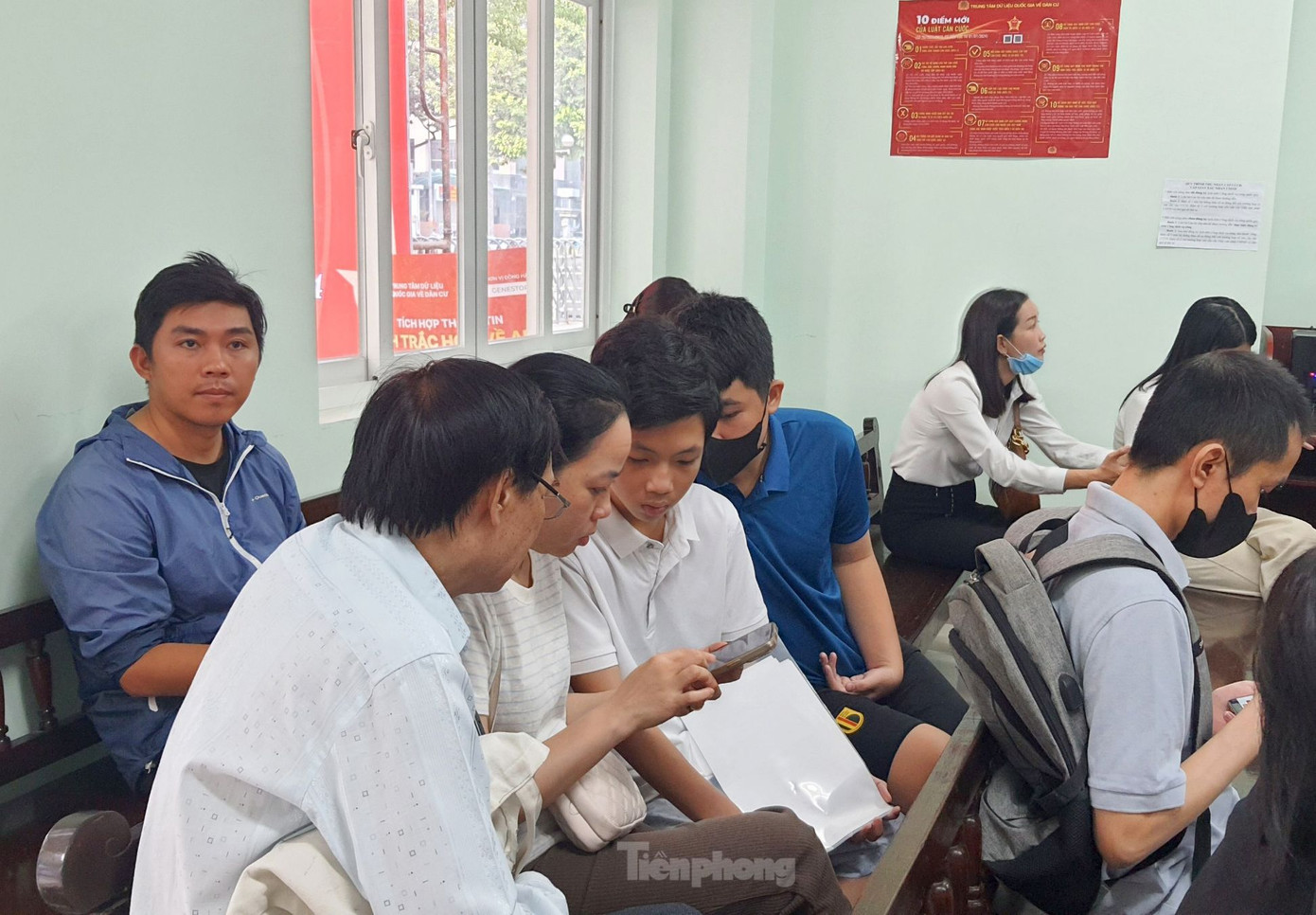 Người dân làm thủ tục cấp thẻ căn cước cho con trên thiết bị điện thoại. Ảnh: Hoàng Thuận.