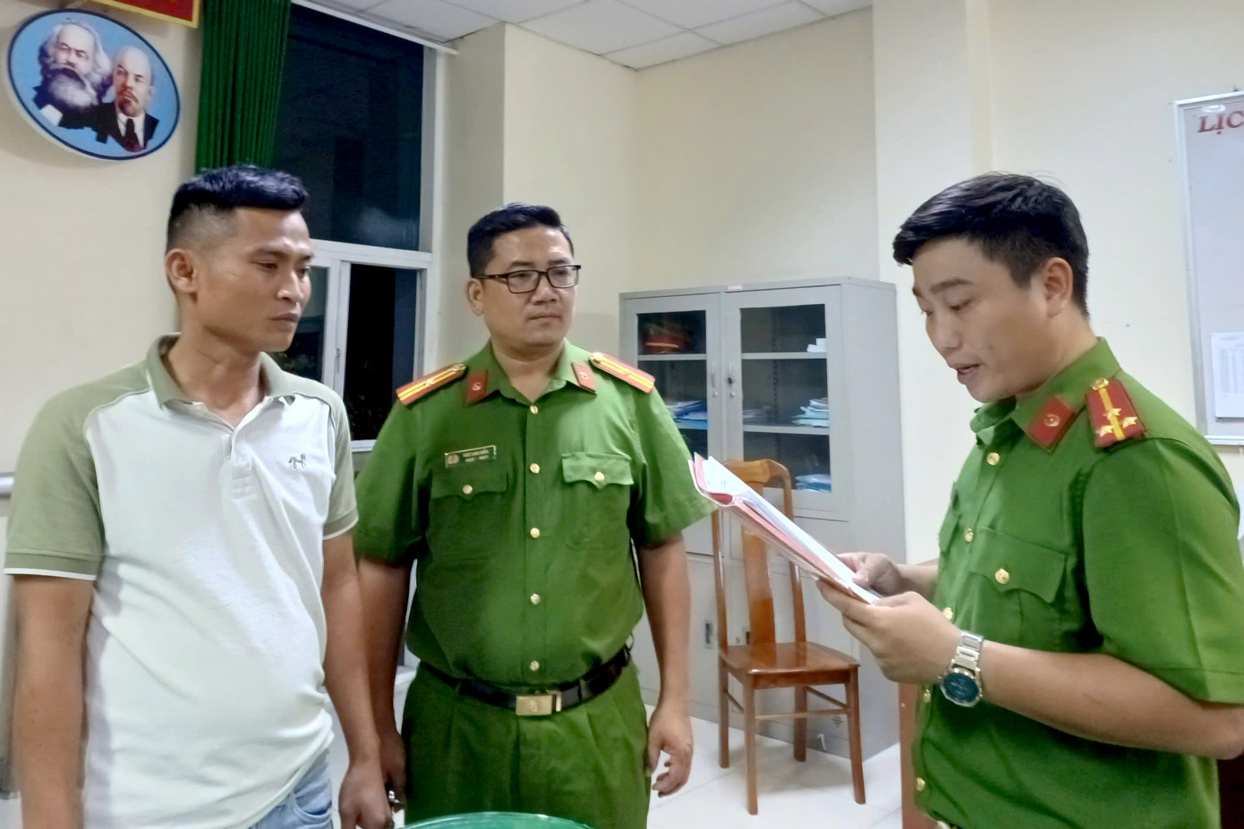 Cơ quan công an tống đạt các quyết định đối với ông Trần Vinh Dự. Ảnh: C.A.