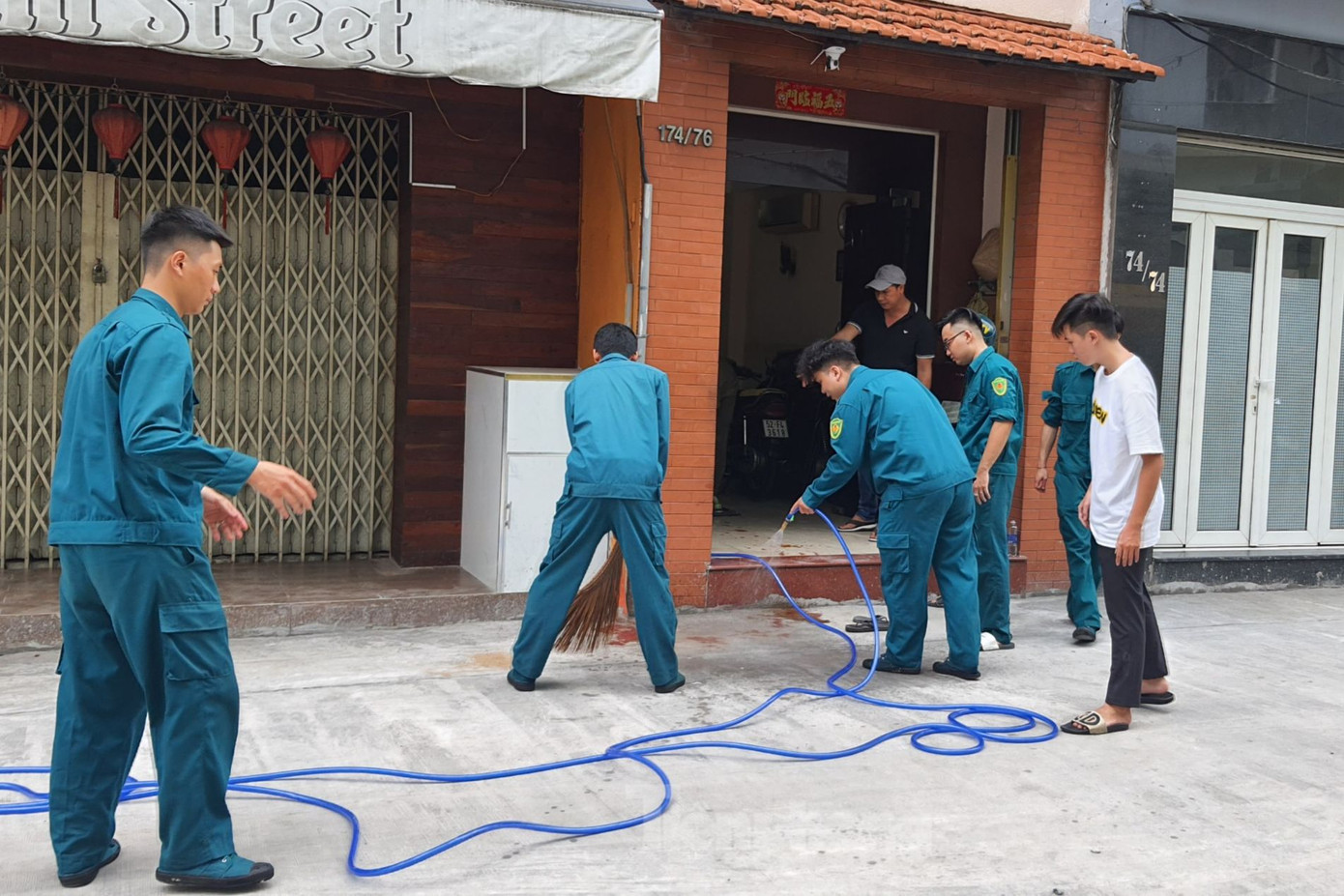 Lực lượng dân quân tẩy xóa vết máu ở hiện trường. Ảnh: Hoàng Thuận.