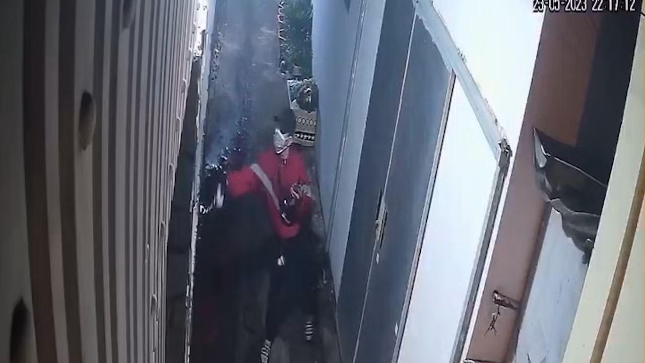 H. tạt sơn vào nhà bà L. được camera ghi lại (Ảnh cắt từ clip). H. tạt sơn vào nhà bà L. được camera ghi lại (Ảnh cắt từ clip).