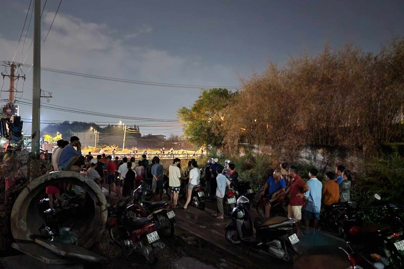 Người dân hiếu kì tập trung tại con kênh để theo dõi sự việc.