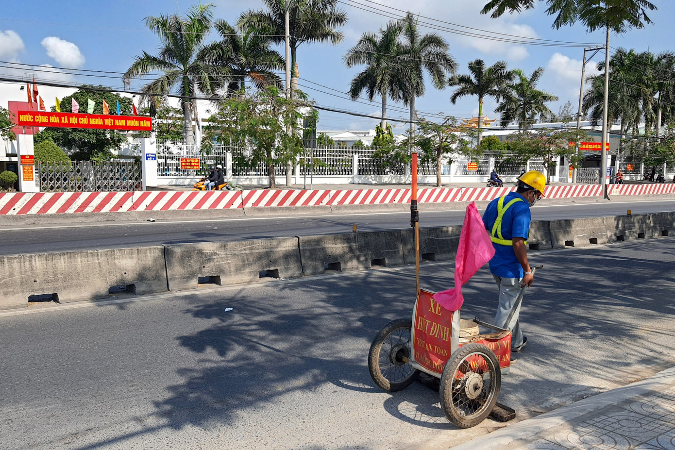 Nhân viên Công ty cổ phần đầu tư và phát triển hạ tầng IDICO kéo xe đi hút đinh. Ảnh: Minh Anh.