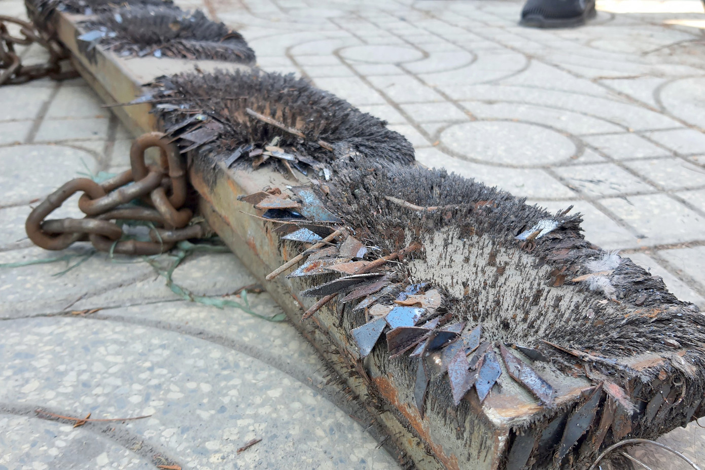 Đinh nhọn rải trên đường dính đầy thanh nam châm của máy hút đinh tự chế. Ảnh: Minh Anh.