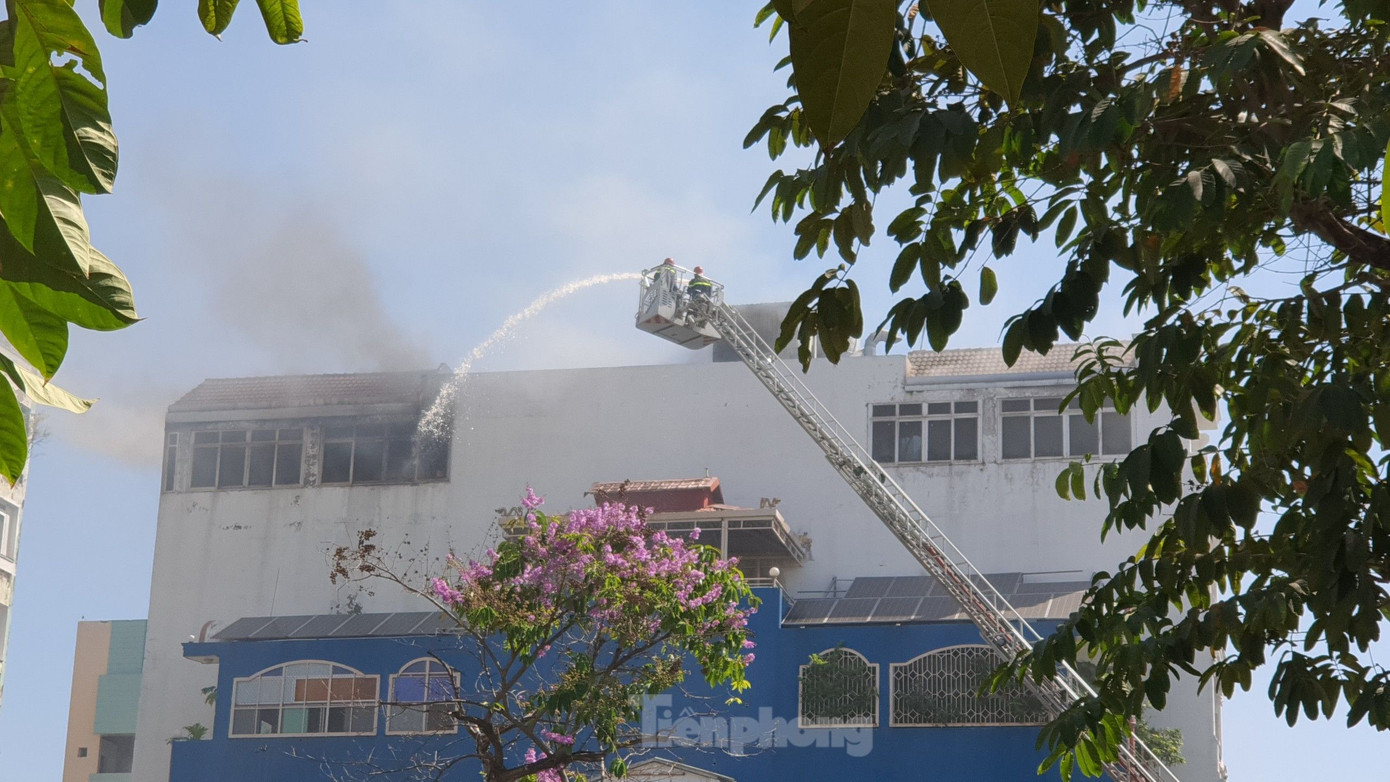 Lực lượng chữa cháy dùng xe thang để phun nước vào bên trong. Ảnh: Hoàng Thuận Lực lượng chữa cháy dùng xe thang để phun nước vào bên trong. Ảnh: Hoàng Thuận