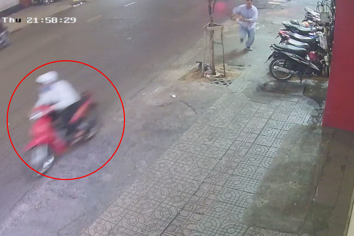 Đối tượng Huy (khoanh tròn đỏ) tăng ga tháo chạy khi giật được điện thoại của du khách Mỹ (Ảnh cắt từ clip).