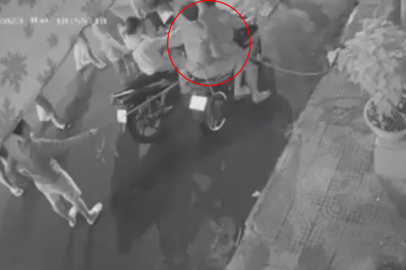 Công an đưa hai nghi phạm (khoanh tròn đỏ) đến dựng lại hiện trường (Ảnh cắt từ clip). Công an đưa hai nghi phạm (khoanh tròn đỏ) đến dựng lại hiện trường (Ảnh cắt từ clip).