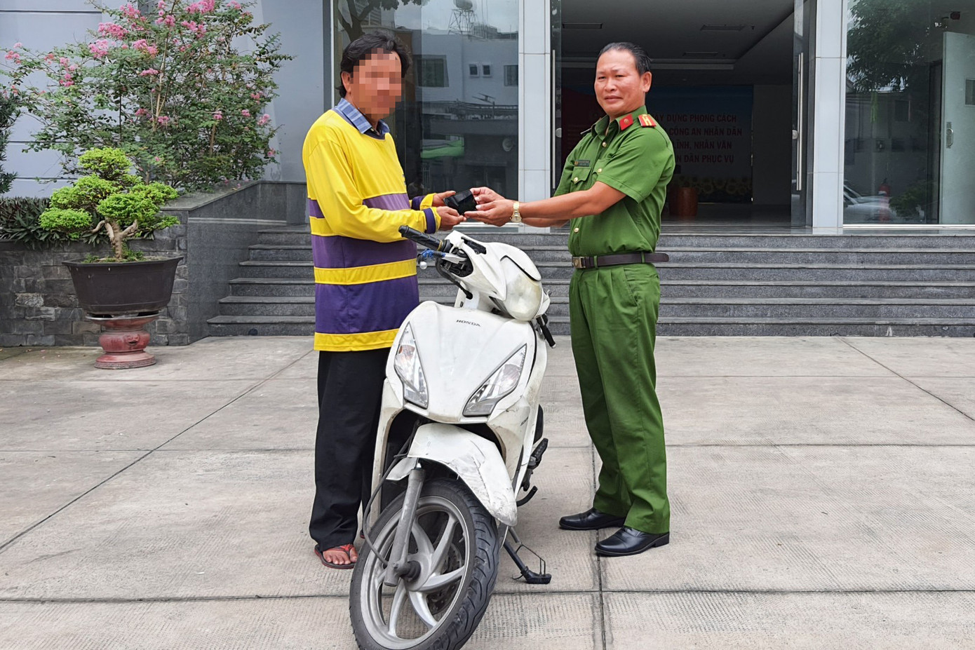 Công an quận 3 trao trả lại điện thoại và xe máy cho tài xế Đ. Ảnh: Hoàng Thuận.