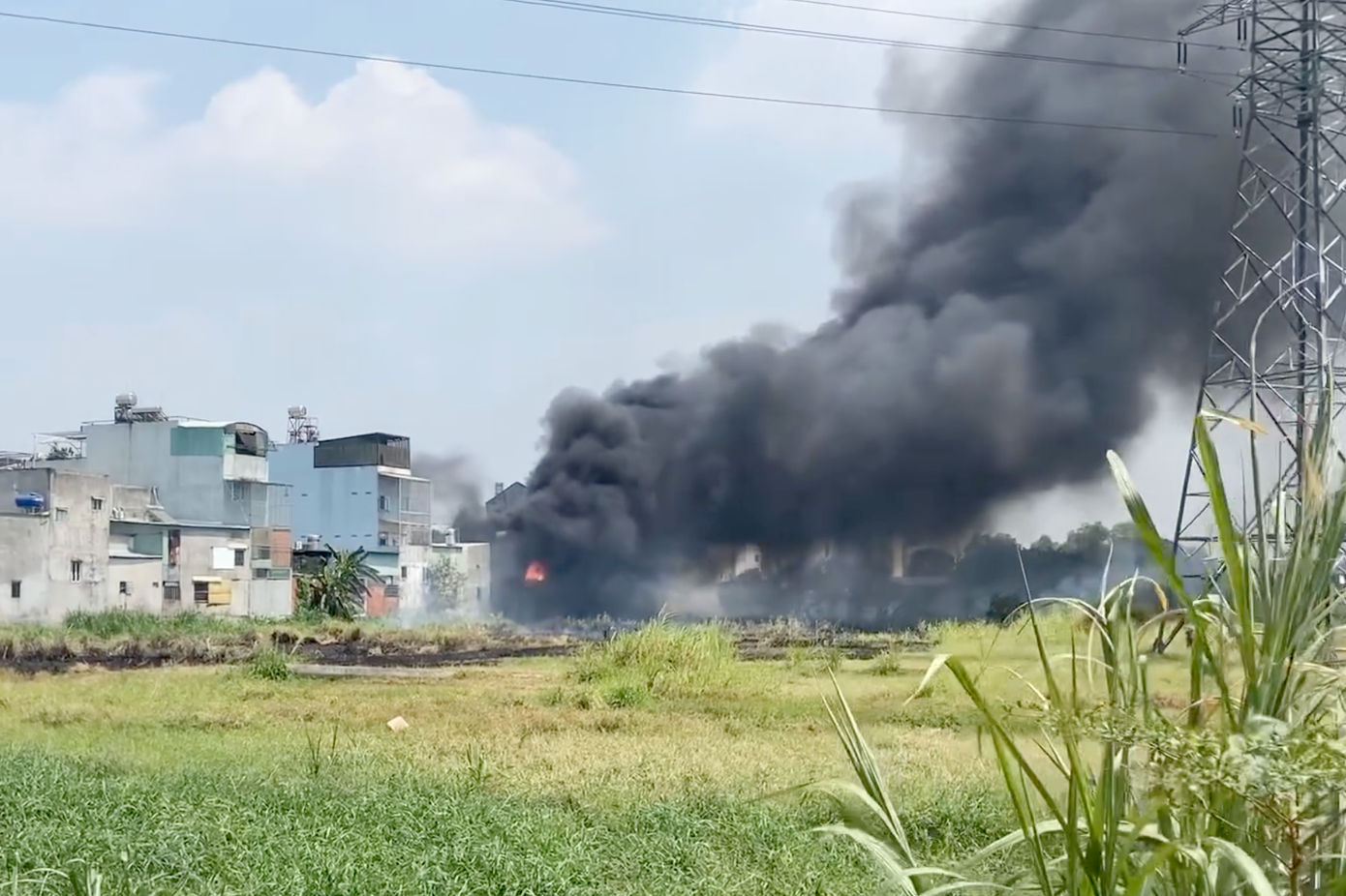 Đám cháy lan từ bãi đất trống vào nhà dân ở huyện Hóc Môn. Ảnh: M.A.