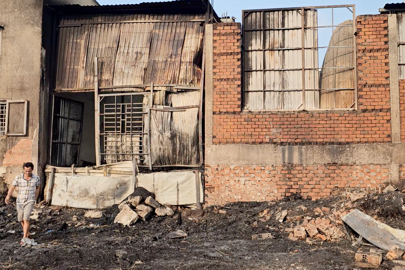 Các nhà dân liền kề tại bãi đất trống bị cháy lan, cháy xém tường gạch. Ảnh: M.A.