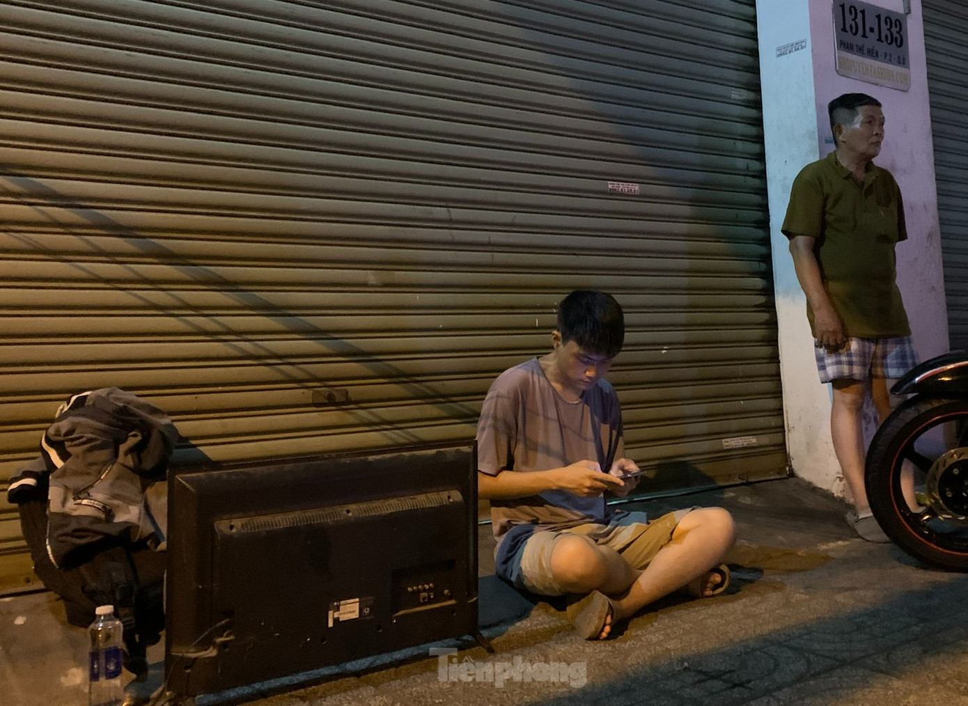 Người dân ôm tivi ra khỏi khu vực bị cháy. Ảnh: Hoàng Thuận.