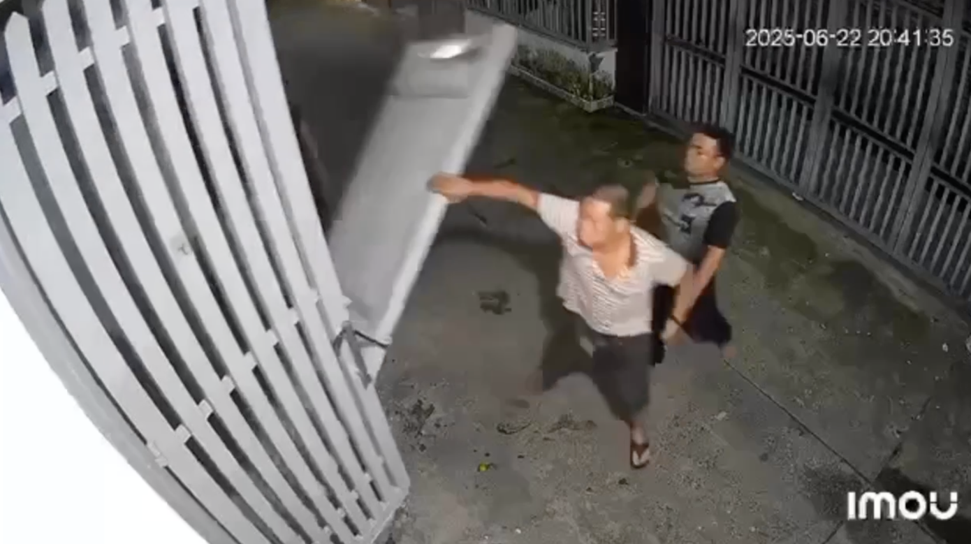 Camera ghi cảnh ông K. kéo ngã cửa sắt. Ảnh cắt từ clip.