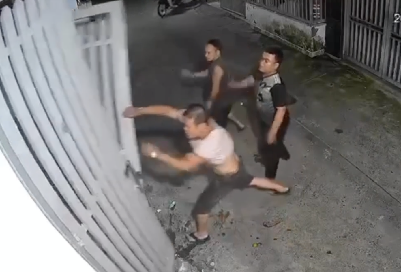 Ông Khánh dùng tay giật sập cửa sắt nhà hàng xóm. Ảnh cắt từ clip.