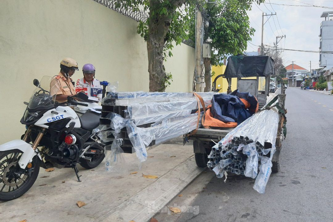 Ông D. chở hàng chục thanh sắt vuông có chiều dài 2,1m lưu thông trên đường. Ảnh: Hoàng Thuận