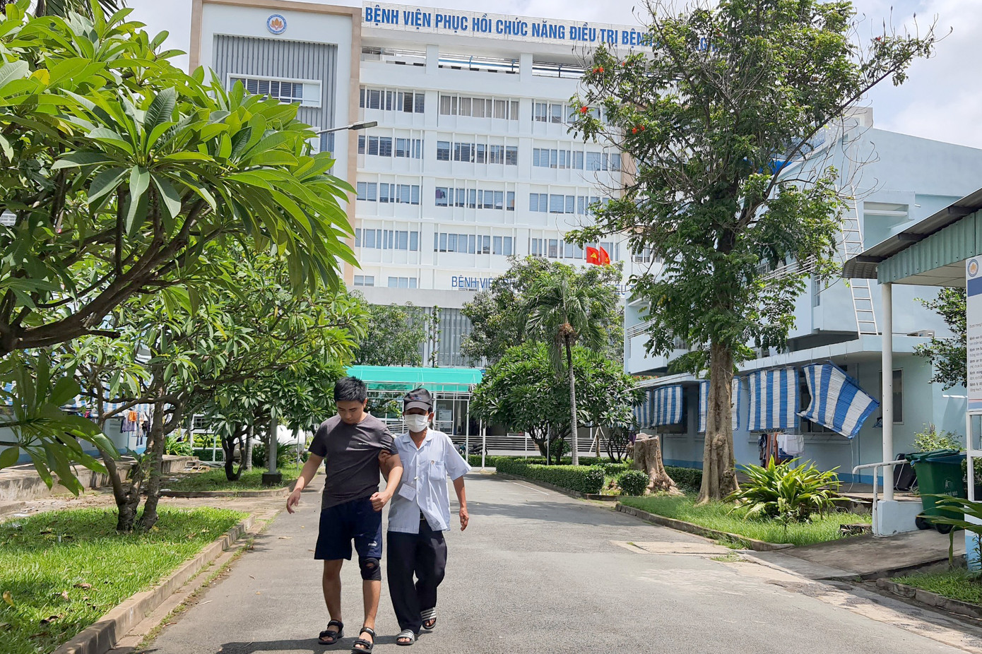 Ông Việt tập cho con trai đi lại. Ảnh: Hoàng Thuận