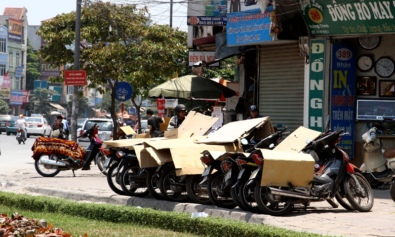 Xe máy được che chắn bằng đủ thứ vật dụng như bìa cát tông, vải bạt