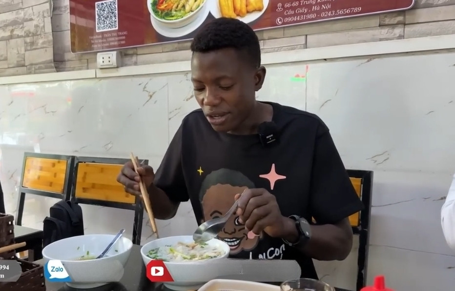 Việc sử dụng đũa ăn không làm khó được Lindo đâu nhé! (Ảnh: Quang Linh Vlogs - Cuộc Sống ở Châu Phi)