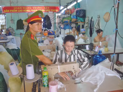 Quản giáo hướng dẫn phạm nhân làm việc. Ảnh: T.LA