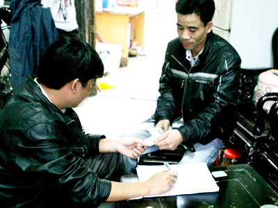 Anh Trần Văn Hiển (phải) đang mua vé tại nhà cò M. Ảnh: M.Đ