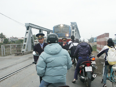 Nhân viên gác tàu ở cầu Tam Bạc cố ngăn cậu thanh niên vượt vì tàu đang đến gần