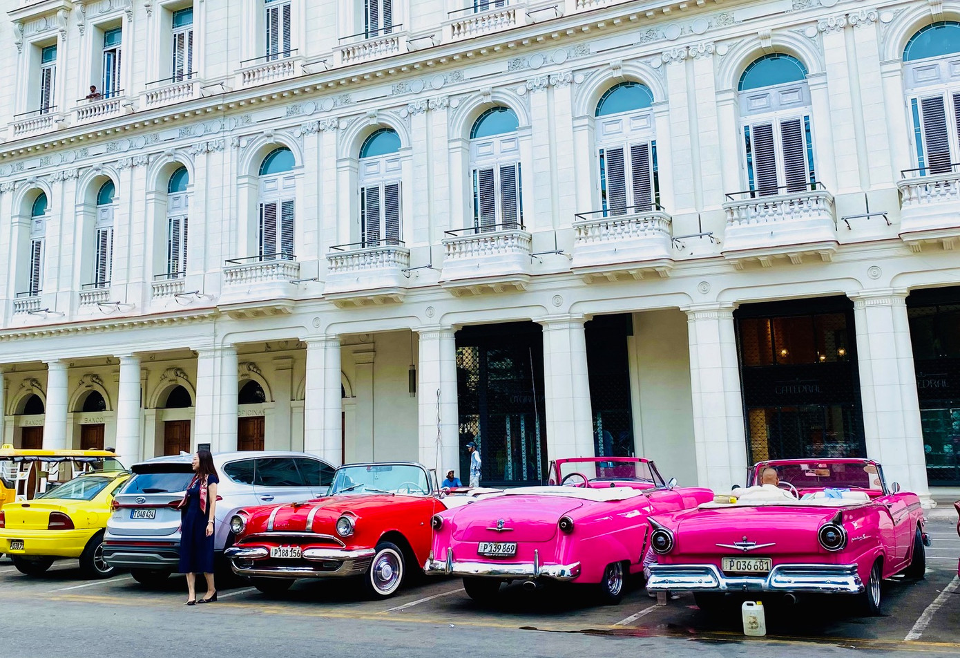 Những chiếc xe cổ đỗ ở trước một toà nhà đẹp ở La Habana