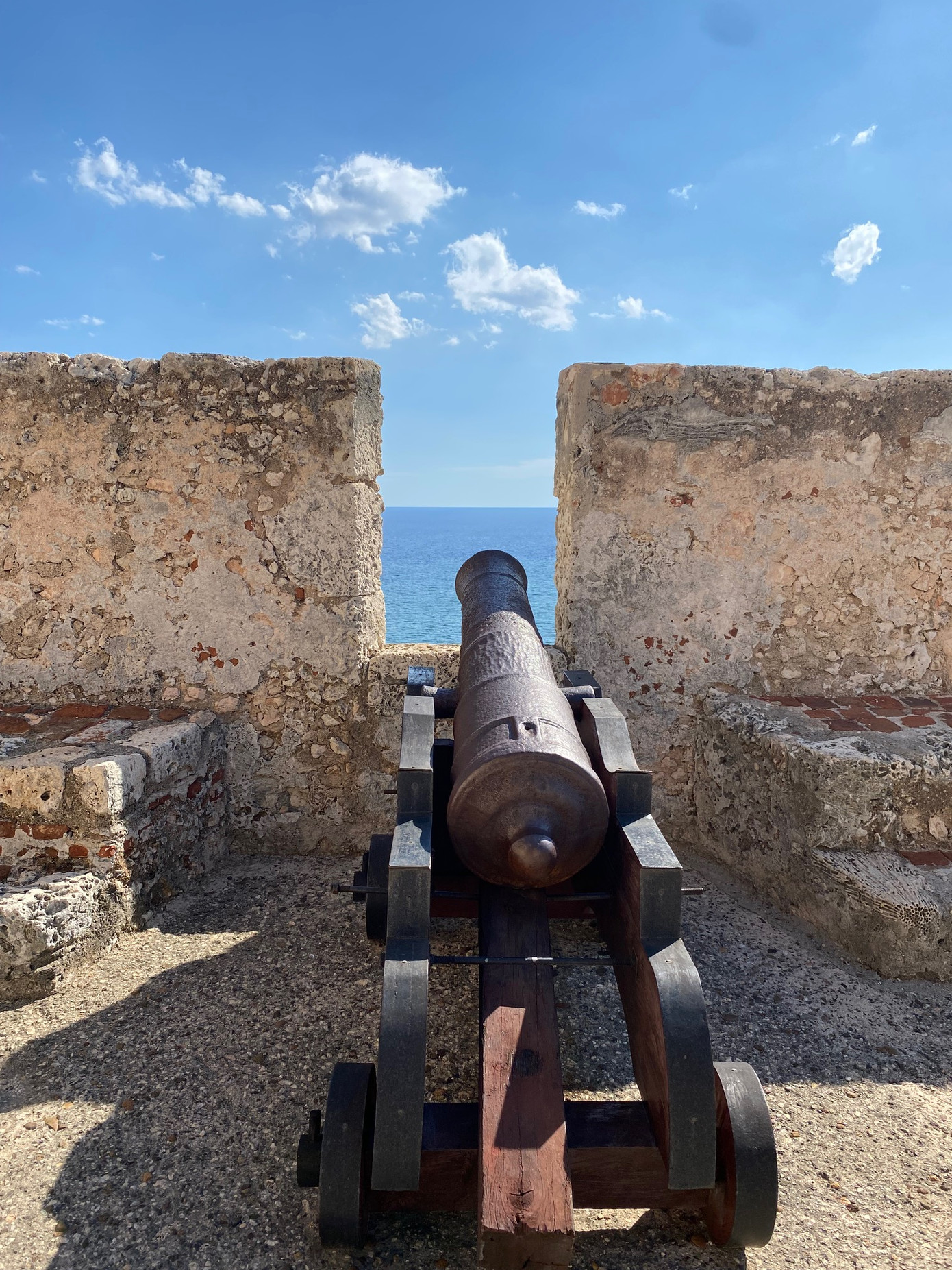 Khẩu đại bác chĩa nòng qua lỗ châu mai trên tường thành xuống cửa biển ở pháo đài San Pedro de la Roca ở TP Santiago de Cuba.