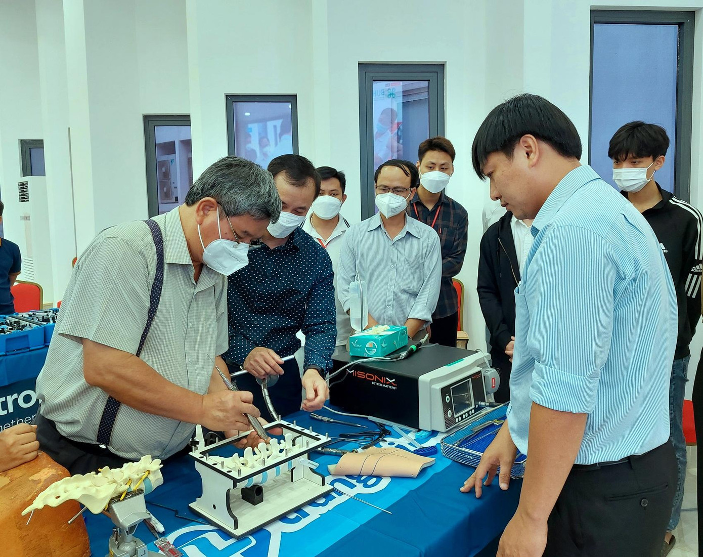 TS.BS Võ Xuân Sơn (bìa trái) và các bác sĩ tiến hành thực hành ứng dụng hệ thống Longitude Sextan II trên mô hình, mổ thị phạm