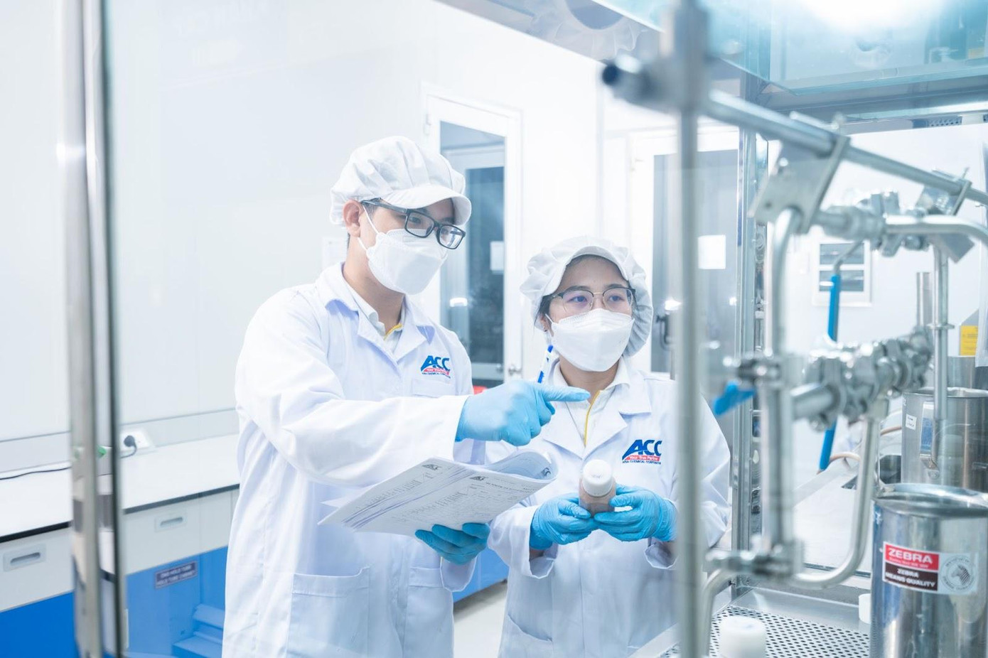 Trần Minh Thuận ( trái) đang cùng đồng nghiệp nghiên cứu các công thức mới