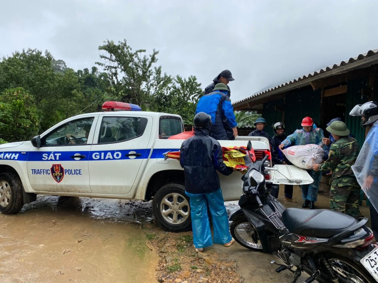 Lực lượng cảnh sát giao thông dùng xe chuyên dụng giúp người dân di dời tài sản đến nơi an toàn, tránh lũ