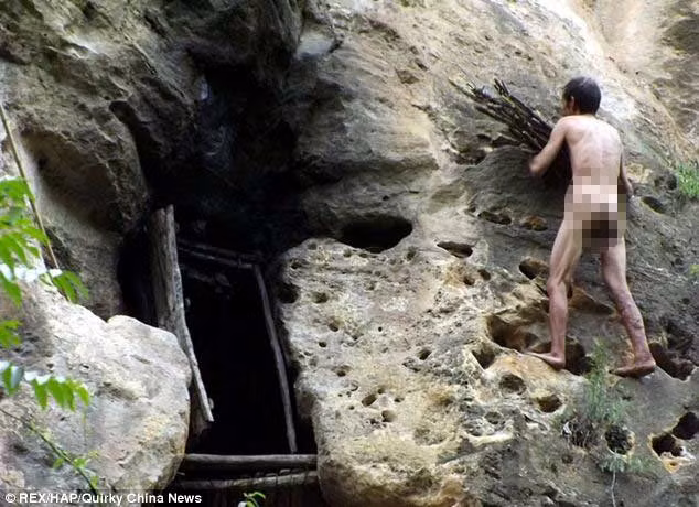 Feng sống trong chiếc hang cao 50 m, anh ta đang mang củi vào hang