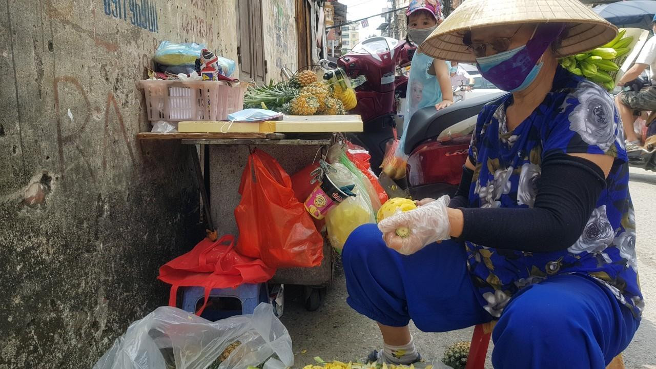Tiểu thương bán dứa "di động" trên xe đẩy, khi bị lực lượng chức năng giải tán thì đẩy xe vào ngõ