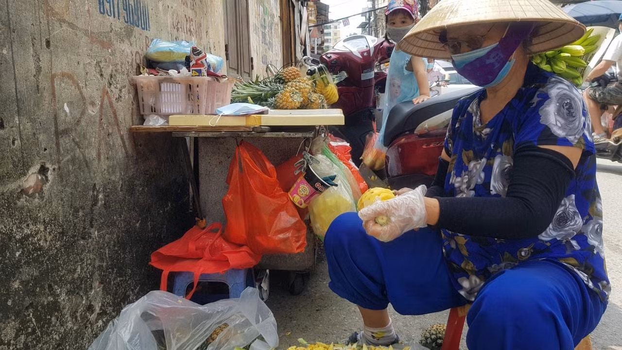 Tiểu thương bán dứa "di động" trên xe đẩy, khi bị lực lượng chức năng giải tán thì đẩy xe vào ngõ