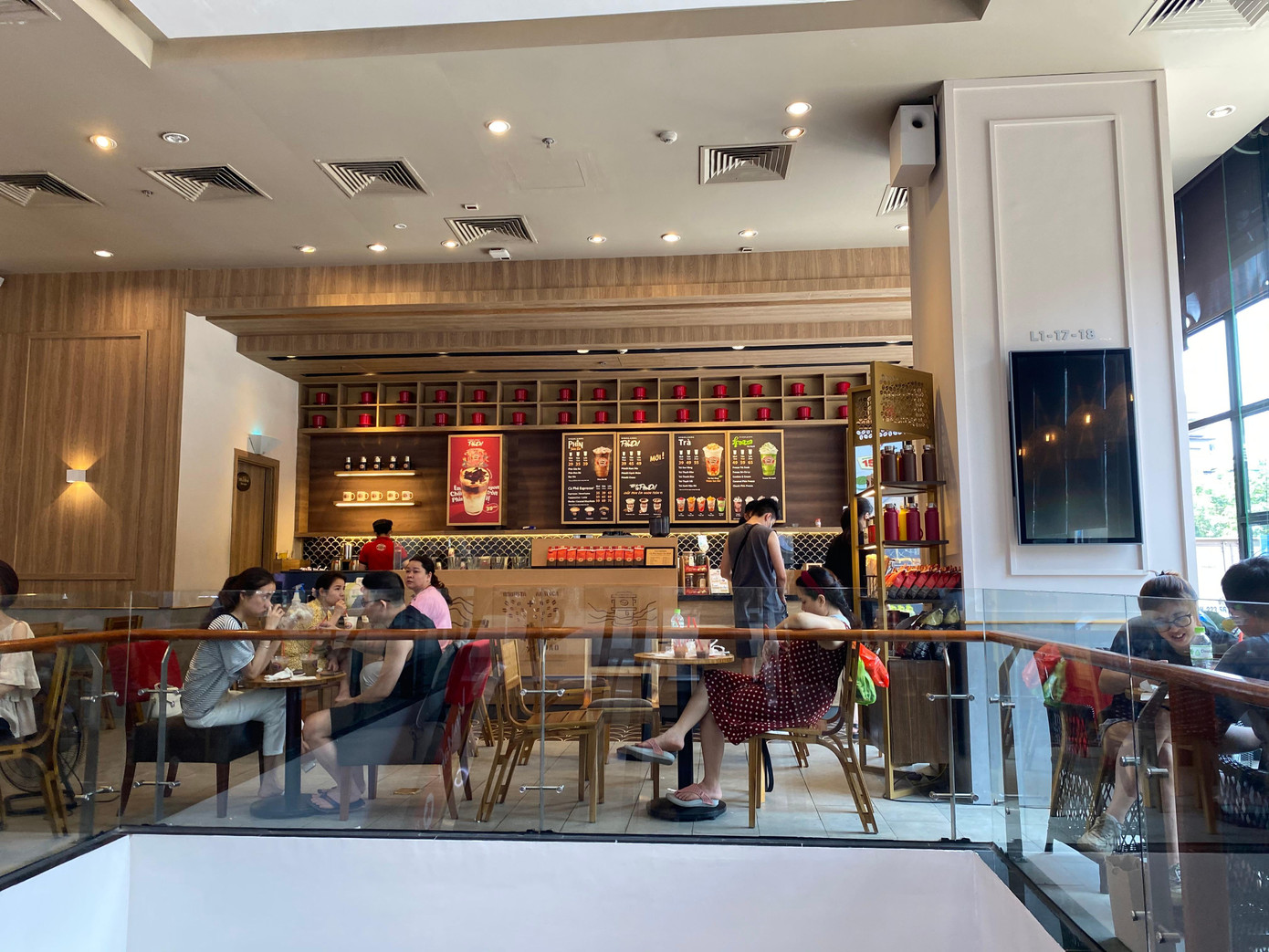 Dù UBND TP Hà Nội yêu cầu các cửa hàng ăn, uống trong nhà phải đảm bảo giãn cách chỗ ngồi tối thiểu 2m nhưng quán cafe tại sảnh trung tâm thương mại vẫn bố trí bàn sát nhau, gần như kín chỗ