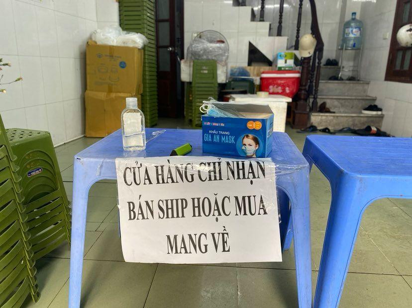 Một quán trên phố Quang Trung chỉ bán mang đi, dừng phục vụ tại chỗ dù có không gian trong nhà rộng rãi. Quán tặng miễn phí khẩu trang, có nước rửa tay cho khách tới mua, nhân viên giao hàng