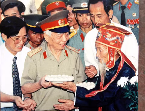 Một lão nông tặng Đại tướng đĩa bánh trôi tượng trưng cho lòng kính trọng của dân làng với người có công với đất nước nhân dịp Đại tướng thăm đình Hát Môn (Hà Tây cũ) năm 1995. 