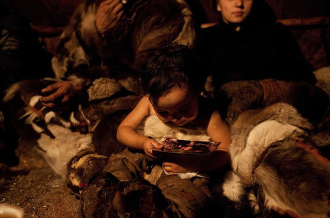 Một em nhỏ chăm chú xem ảnh. Ảnh: Sash Leahovcenco