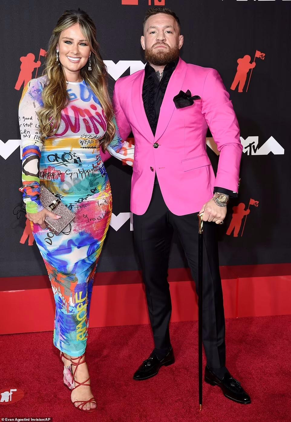 Võ sĩ MMA Conor McGregor mặc vest hồng, áo bèo nhún vẫn không che được ngoại hình cơ bắp, nam tính. Anh dự sự kiện với bạn gái Dee Devlin.