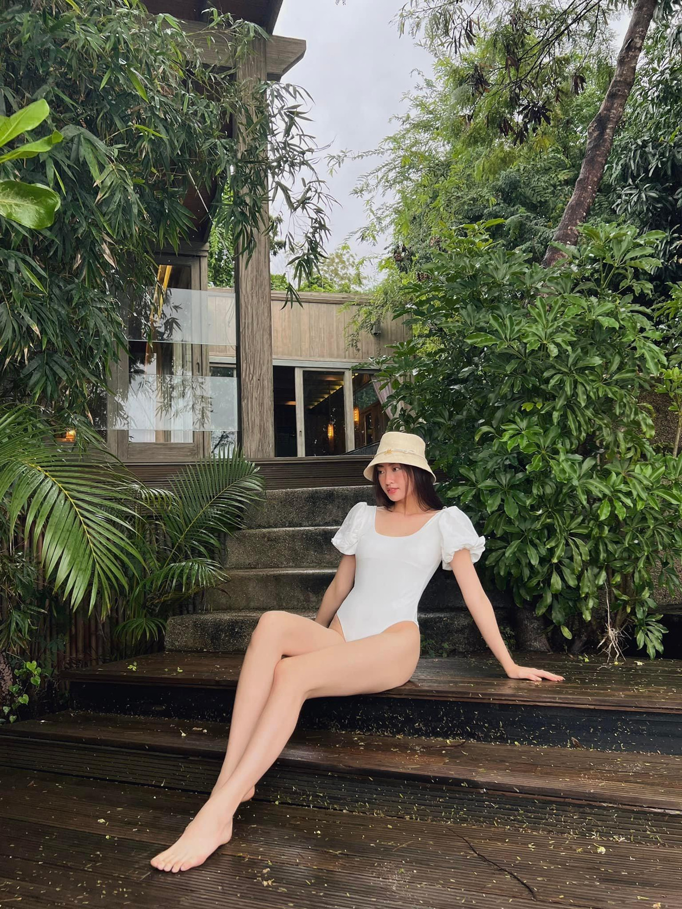 Cũng là tông màu trắng nhưng thiết kế áo tắm một mảnh kín đáo tập trung vào điểm nhấn là đôi chân 1m22 'trứ danh' của nàng hậu gốc Cao Bằng.