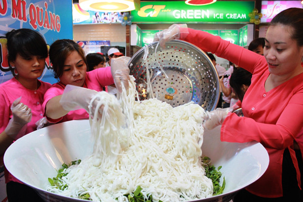 Rồi cho mì Quảng rải đều và tạo điểm nhọn trên tô