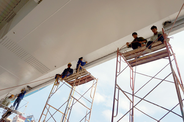 Những người thợ sơn treo leo quét những tại gầm cầu