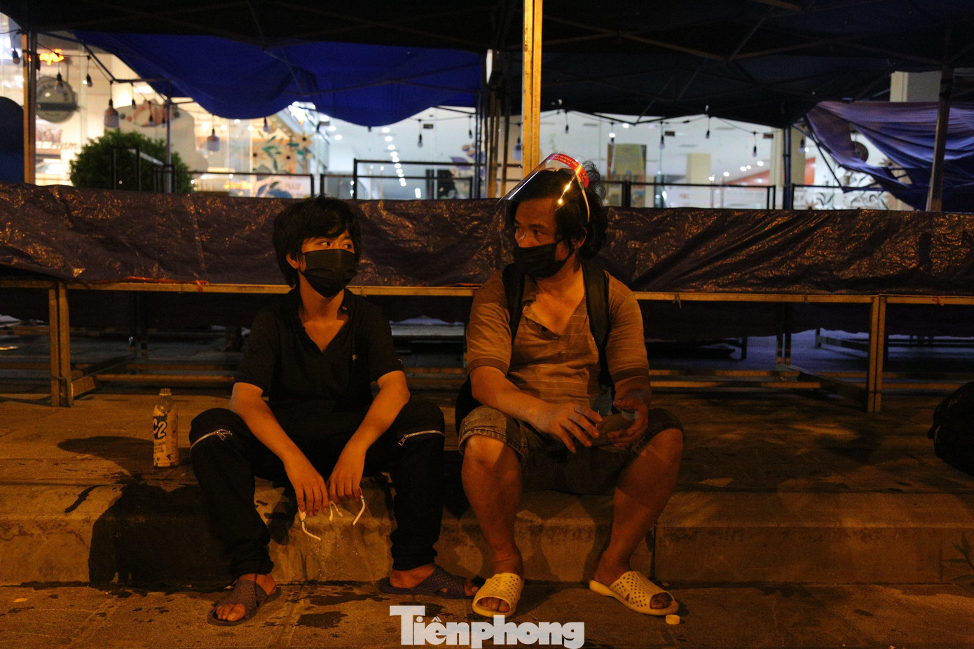 10h đêm, hai bố con anh Nguyễn Văn Sơn ngồi vất vưởng ở lề đường đoạn Nguyễn Trãi (quận Thanh Xuân, TP. Hà Nội). Hai bố con anh từ huyện Nghĩa Hưng (Nam Định) lên Hà Nội làm bốc vác cho một công trình ở gần ga Hà Nội trước thời điểm chưa giãn cách xã hội có mấy ngày. Sáng 24/7, chủ thầu thông báo phải tạm dừng công việc, anh Sơn kêu họ trả tiền công nhưng đến nay vẫn “bặt vô âm tín”.