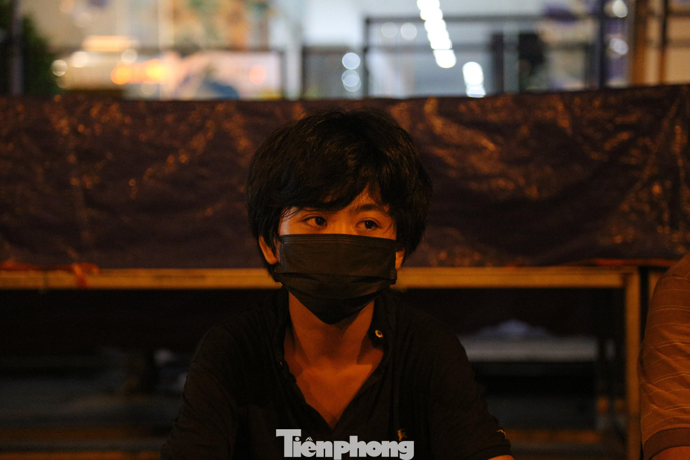 Con trai anh Sơn lang thang cùng bố chờ ngày được trở về quê Anh Sơn cho biết, hàng ngày hai bố con anh đi lang thang khắp nơi để xin cơm từ thiện. Buổi tối, khi đã thấm mệt, hai người chọn một vỉa hè hay một gầm cầu nào đó làm nơi nghỉ tạm. Trong ảnh là Đinh Quang Đạt quê Mai Châu, Hòa Bình. Đạt đang ăn ở tại tại khu vực gầm cầu vành đai 3 dọc đường Khuất Duy Tiến (đoạn qua hồ điều hòa Nhân Chính). Tối đến, Đạt lại rời nơi trú ngụ của mình để đi nhặt phế liệu. “Em sợ con virus này lắm, nên đi đêm ít người nên chắc sẽ bớt bị ảnh hưởng hơn. Với lại, ban ngày nóng bức cộng em lo không làm ăn được gì mấy. Không biết bao giờ mới đủ tiền bắt xe về quê”, thanh niên người dân tộc Thái cười nói. Đạt cho biết, nhà nghèo, mẹ bị bệnh tật liên miên, không lao động nặng được. Đạt bỏ học sớm để đi làm phụ hồ kiếm tiền nuôi mẹ. Mới đây, em làm cốt pha cho một nhà chủ ở tỉnh Hưng Yên. Do dịch bệnh, công việc không được thuận lợi, Đạt tính đi về nhà ở huyện Mai Châu (Hòa Bình) nhưng do không thông thuộc đường, Đạt lạc lên Hà Nội đúng vào thời điểm giãn cách xã hội. Đạt cho biết, lúc mới lên Hà Nội, em ở trọ cùng một người bạn mới quen. Tuy nhiên, mới ở một đêm, hôm sau ngủ dậy cả ví tiền, điện thoại, quần áo, giấy xét nghiệm COVID-19 bị lấy cắp mất cả. Đạt đành phải ra gầm cầu ở và hàng đêm đi nhặt phế liệu để hôm sau bán lấy tiền mua mỳ tôm sống qua ngày. Dưới gầm cầu đường vành đài 3 dọc quốc lộ 1A (đoạn gần bến xe Nước Ngầm) là nơi trú ngụ của ba người đàn ông khác đến từ Nam Định, Điện Biên và Nghệ An. Hàng ngày, họ trông chờ vào những suất cơm từ thiện, nếu không thì nhai mỳ tôm sống. Mọi sinh hoạt cá nhân, sạc pin điện thoại, họ nhờ các nhà dân gần đó trợ giúp. Anh Lô Văn Cà Huệ (quê huyện Quế Phong, tỉnh Nghệ An) tâm sự, anh lên Hà Nội tìm việc từ đợt Tết 2021. Công việc cơ khí dân dụng bên quận Long Biên của anh vẫn suôn sẻ đến khi Hà Nội thực hiện những biện pháp thắt chặt để phòng chống dịch. “Tôi đi làm lương được 5 triệu đồng/tháng. Đóng tiền trọ 1 tháng hết khoảng 1,2 triệu đồng, giờ mất việc tôi ra đây với anh em cho tiết kiệm tiền trọ”, thanh niên người dân tộc Thái chia sẻ. Trình duyệt của bạn không hỗ trợ hiển thị video. Clip: Đinh Quang Đạt kể về cuộc sống ngày ở gầm cầu, đêm nhặt rác của mình