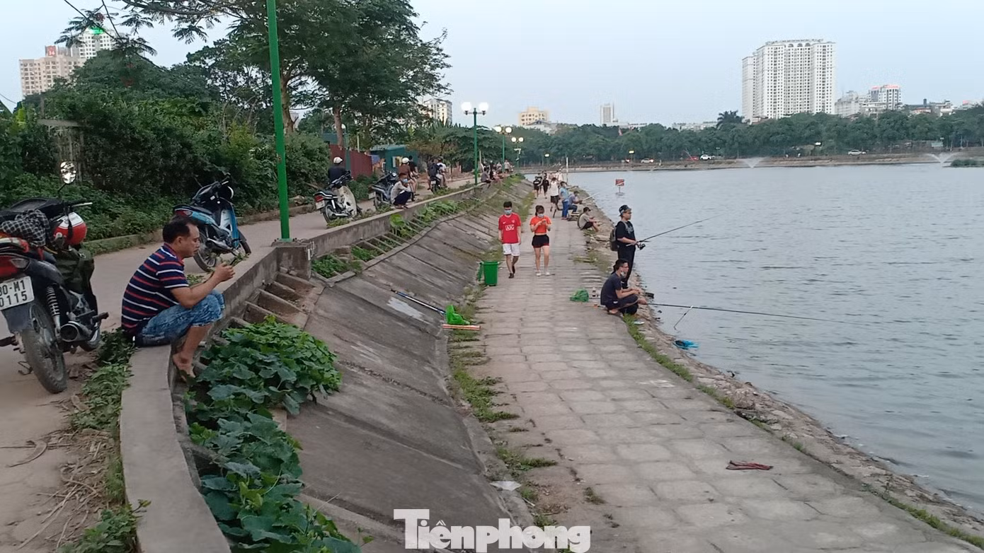 Ghi nhận của PV chiều 21/5, tại hồ Định Công (Hoàng Mai, Hà Nội), bên cạnh dòng người đông đúc chạy bộ, tập thể dục thì khu vực mép hồ, hàng chục cần thủ vẫn bình thản ngồi câu cá.