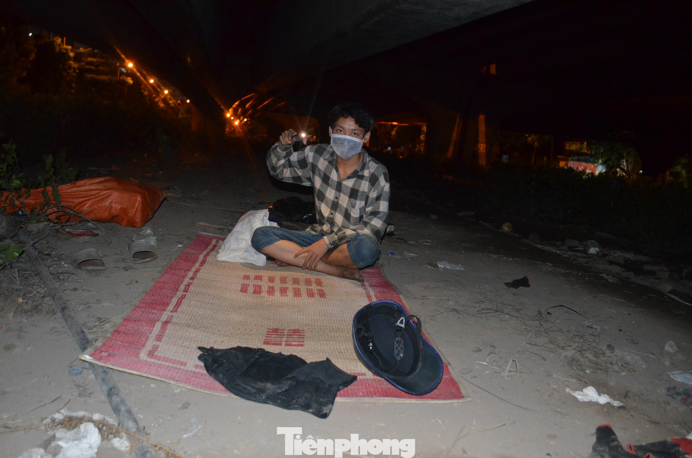 Trong ảnh là Đinh Quang Đạt quê Mai Châu, Hòa Bình. Đạt đang ăn ở tại tại khu vực gầm cầu vành đai 3 dọc đường Khuất Duy Tiến (đoạn qua hồ điều hòa Nhân Chính). Tối đến, Đạt lại rời nơi trú ngụ của mình để đi nhặt phế liệu.